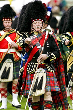 Drum Major leads massed band of Scottish pipers at the Braemar Games Highland Gathering