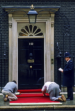 Policeman watches  red carpet being laid outside number 10 Downing Street, the home of the Prime Minister, London, UK.