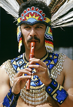 Man in Mexican Aztec Indian outfit plays recorder, United States of America