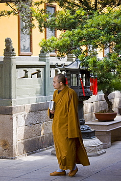 Buddhist monk in saffron robes at the Jade Buddha Temple, Shanghai, China