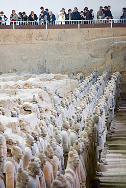 Tourists view infantry figures from the edge of Pit 1 at Qin Museum, exhibition halls of Terracotta Warriors, China