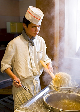 Chef cooking noodles in tourist restaurant, Xian, China