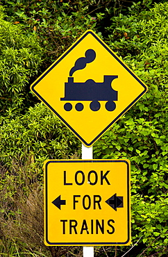 Road traffic sign 'look  for trains' on railway crossing, North Island, New Zealand