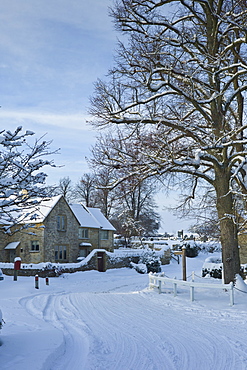 Traditional cottage during snowy weather in the village of Swinbrook, The Cotwolds