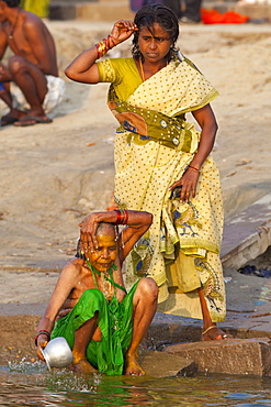 Indian Hindu pilgrims bathing in The Ganges River at Dashashwamedh Ghat in Holy City of Varanasi, Benares, India