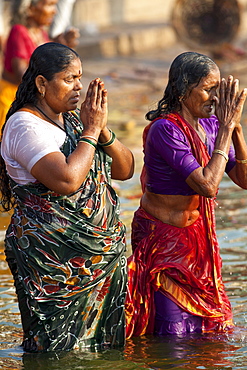 Indian Hindu pilgrims bathing in The Ganges River at Dashashwamedh Ghat in Holy City of Varanasi, Benares, India