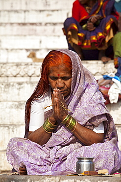 Indian Hindu pilgrims  praying by The Ganges River at Dashashwamedh Ghat in Holy City of Varanasi, Benares, India