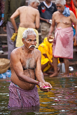 Indian Hindu pilgrims bathing in The Ganges River at Dashashwamedh Ghat in Holy City of Varanasi, Benares, India