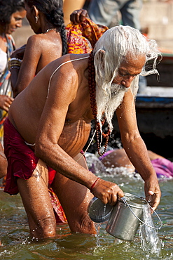 Indian Hindu pilgrim bathing in The Ganges River at Dashashwamedh Ghat in Holy City of Varanasi, Benares, India