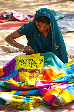 Indian woman sewing textiles at Dastkar women's craft co-operative, the Ranthambore Artisan Project, in Rajasthan, Northern India