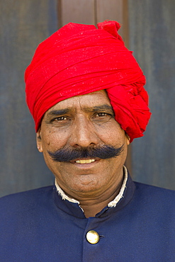 Palace guard in achkan suit at former Royal Guest House in the Maharaja's Moon Palace in Jaipur, Rajasthan, India