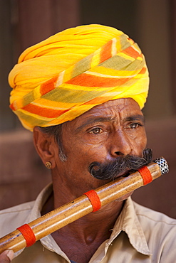 Hindu musician playing flute wind instrument at Mehrangarh Fort at Jodhpur in Rajasthan, Northern India