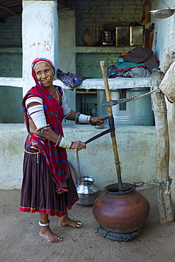 Indian woman making buttermilk at home in Narlai village in Rajasthan, Northern India