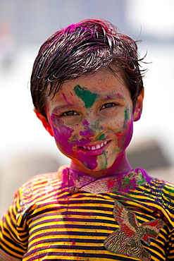 Young Indian boy celebrating annual Hindu Holi festival of colours with powder paints in Mumbai, formerly Bombay, Maharashtra, India