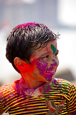 Young Indian boy celebrating annual Hindu Holi festival of colours with powder paints in Mumbai, formerly Bombay, Maharashtra, India