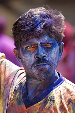 Indian man celebrating annual Hindu Holi festival of colours smeared with powder paints in Mumbai, formerly Bombay, Maharashtra, India