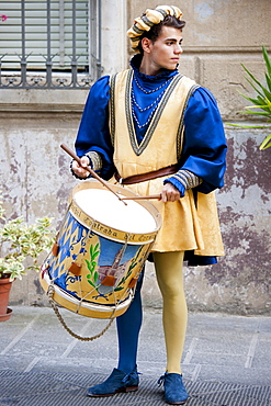 Contrada members in livery costumes for traditional parade in Asciano, Tuscany, Italy