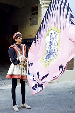 Contrada young man in livery costume at traditional parade in Asciano, inTuscany, Italy