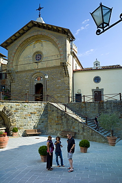 Tourists by Tuscan Church of San Niccolo, Chiesa San Niccolo, in Piazza Francesco Ferrucci in Radda-in-Chianti, Tuscany, Italy