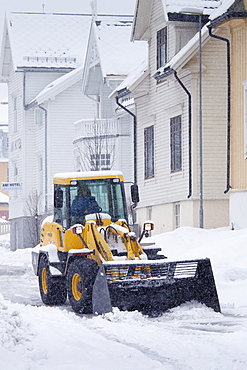 Worker drives Komatsu WA90 snow plough to clear the road in Skolegata in city of Tromso, in the Arctic Circle in Northern Norway