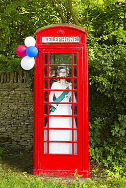 Cutout image of Queen Elizabeth II in phonebox at street party to celebrate the Diamond Jubilee in Swinbrook in the Cotswolds, UK