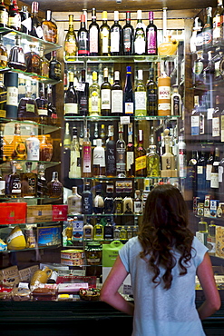 Young girl at liquor store and souvenir shop in Santiago de Compostela, Galicia, Spain