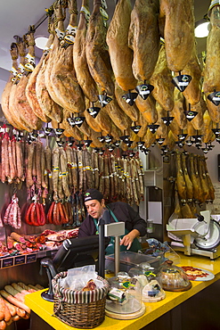 Man at work in butcher's shop selling Iberico Ham and other meats in Calle de Bidebarrieta in Bilbao, Spain