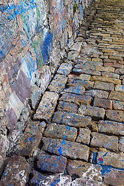 Abstract paint colour splashes where boats painted by sea wall in harbour of Castro Urdiales, Cantabria, Spain