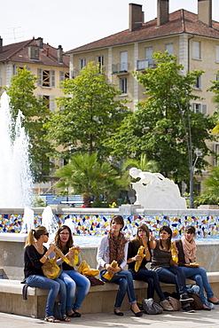 Young office workers eat sandwiches in Place Clemenceau during lunch break in Pau, the Pyrenees, France