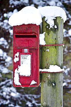 Postbox in snow scene in The Cotswolds, Swinbrook, Oxfordshire, United Kingdom