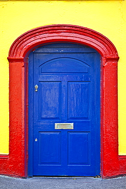 Brightly coloured red blue doorway yellow wall of Furlong's Bar in Passage East, Co. Waterford, Ireland