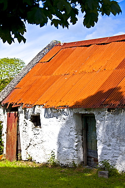 Whitewashed barn with rusty corrugated iron roof in County Cork, Ireland