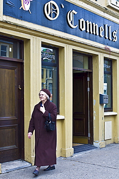 Elderly woman strolls past O'Connells bar in Charleville, County Cork