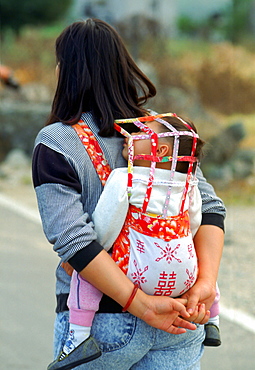 Mother with  child in a baby carrier, Hong Kong