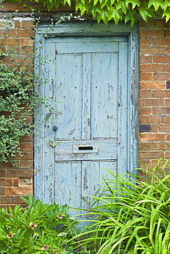 Peeling paint on a doorway in the Cotswolds village of Bledington, Oxfordshire, UK