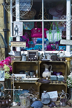 Tourist leaving curiosity shop selling souvenirs, collectibles and gift items in Chipping Campden, The Cotswolds, UK