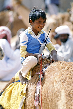 Boy jockey camel racing with walkie talkie radio early cellphone in Al Ain, Abu Dhabi, United Arab Emirates, Middle East