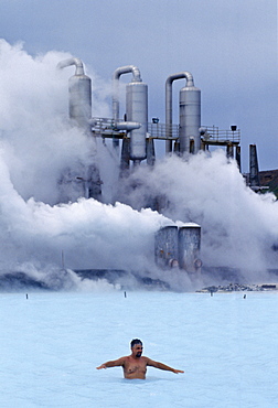 Clouds of steam rise as people swim in the Blue Lagoon thermal pool, Iceland