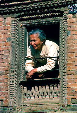 Woman at wooden carved decorated window, Patan, Nepal