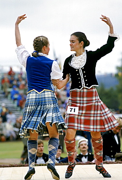 Scottish girls in tartan kilts dancing traditional dance at the Braemar Royal Highland Gathering, the Braemar Games in Scotland