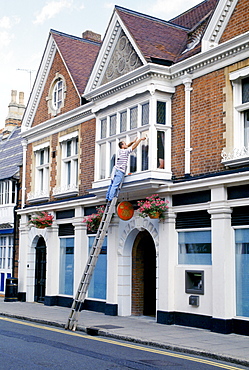 Windows being cleaned at Coutts and Co. bank which provides banking for pupils at nearby Eton College public school, England, UK