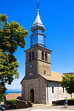 Tourist photographs Saint Pancrace d'Yvoire church in the old district of Yvoire by Lac Leman (Lake Geneva), Rhone-Alpes, France, Europe