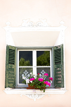 Window in old painted stone 17th century building in the Engadine Valley in the village of Guarda, Graubunden, Switzerland, Europe