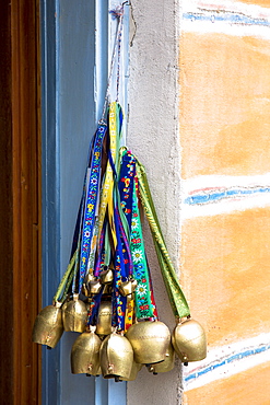 Swiss cow bells on sale at gift shop in the quaint Engadine Valley village of Guarda, Graubunden, Switzerland, Europe