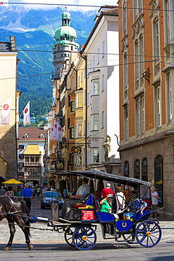 Tourists view Goldenes Dachl (Golden Roof) from horse-drawn carriage by Herzog Friedrich Strasse, Innsbruck the Tyrol, Austria, Europe