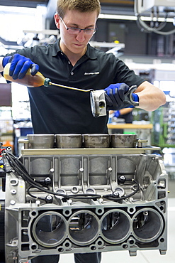 Engineer applying lubricating oil to piston for 6.3 litre V8 engine, Mercedes-AMG engine production factory in Affalterbach, Bavaria, Germany, Europe