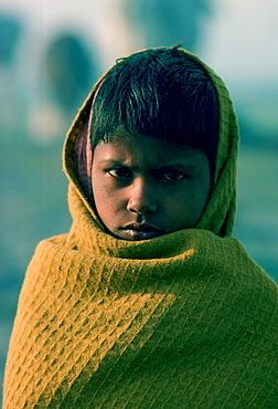 Boy wrapped against the chill morning, Delhi, India