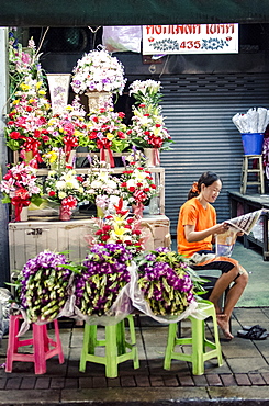 A flower seller reads the morning newspaper, Pak Khlong Flower Market, Bangkok, Thailand, Southeast Asia, Asia 