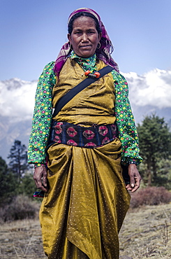 A woman wearing traditional dress in front of the Himalaya mountains, Mere Danda, Helambu, Nepal, Asia