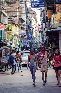 Westerners covered in coloured powder during Holi festival celebrations, Basantapur Durbar Square, Kathmandu, Nepal, Asia 